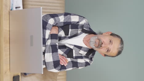 Vertical-video-of-Old-man-looking-at-laptop-is-thoughtful.